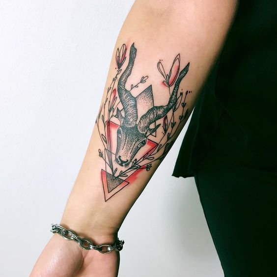 A dual-color goat tattoo on the forearm