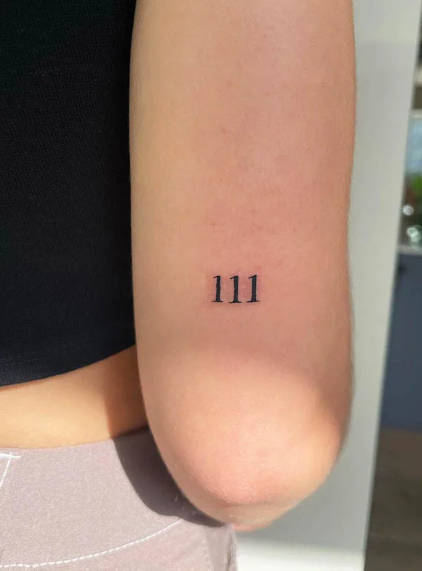 Small angel number tattoo on the arm