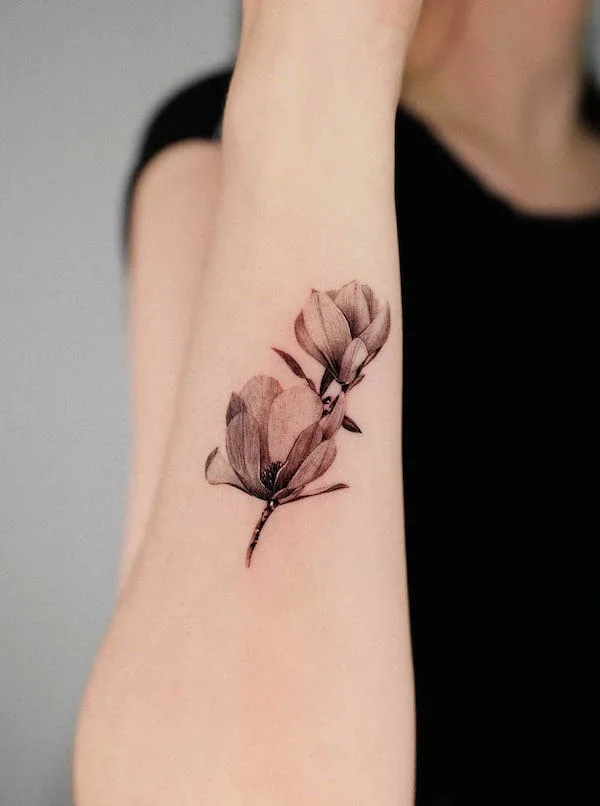 Magnolia flower tattoo on the side of the forearm
