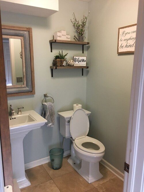 Soft green walls with rustic floating shelves