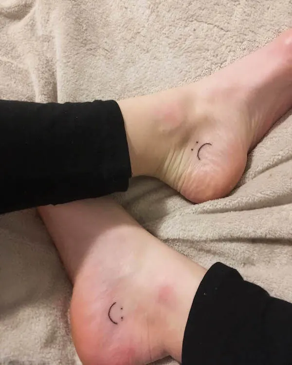 Smiley and crying face ankle tattoos
