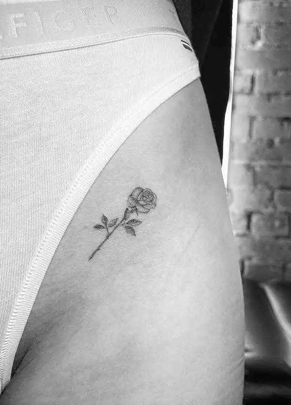 Tiny rose tattoo on the thigh