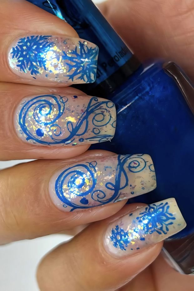 Enchanting Winter Nail Art Featuring Blue Snowflakes and Glitter